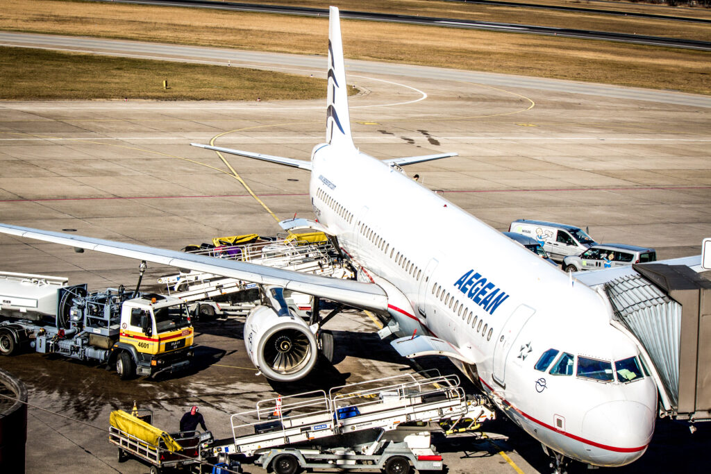 Aircraft on the tarmac, surrounded by ground support vehicles and machinery.