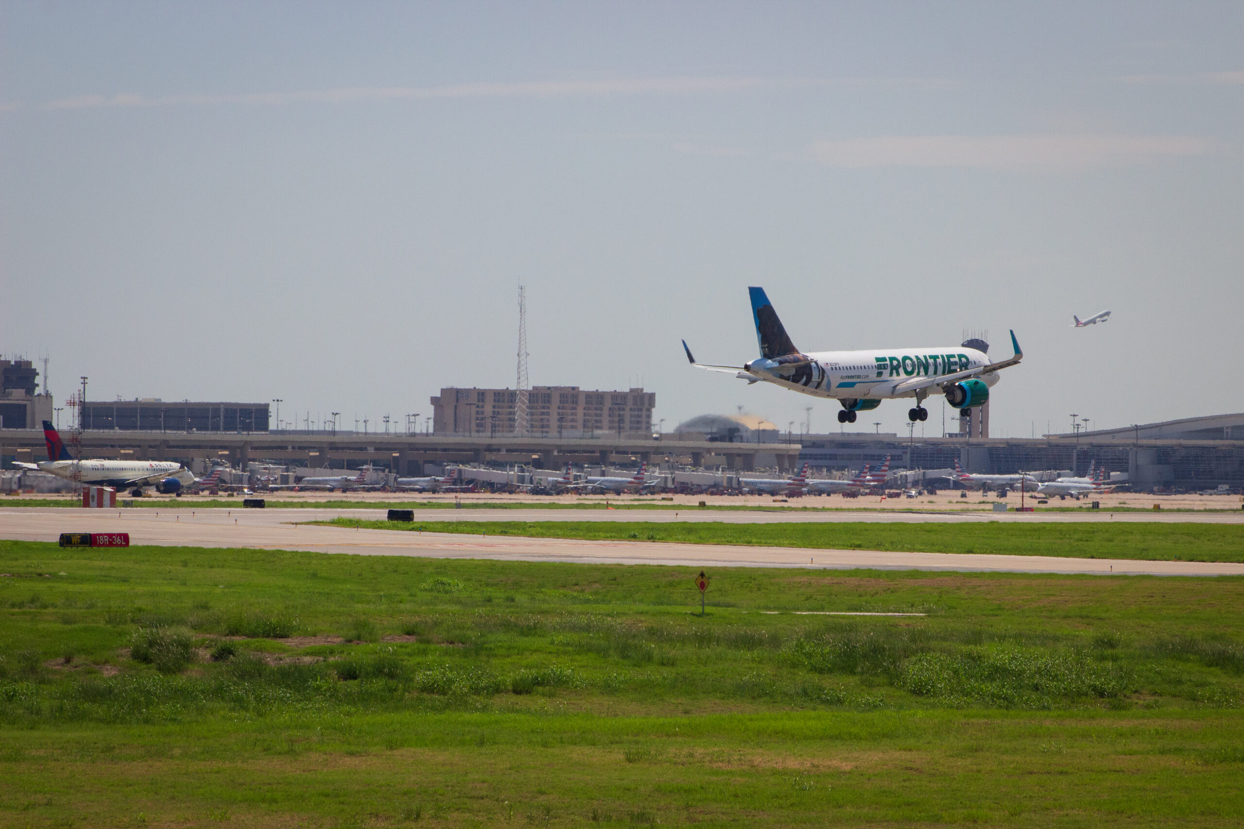 Plane landing with airport in background.