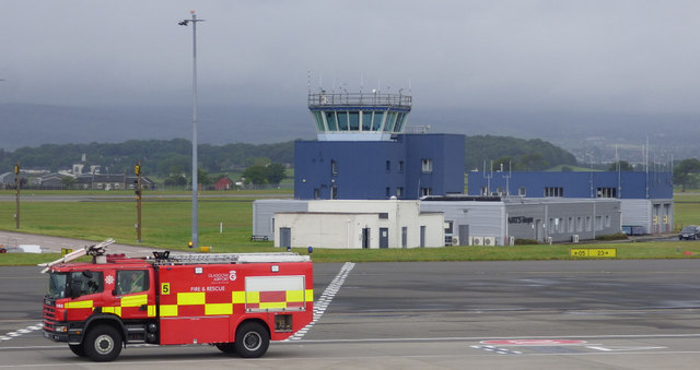 Fire tender in front of an air traffic control tower.